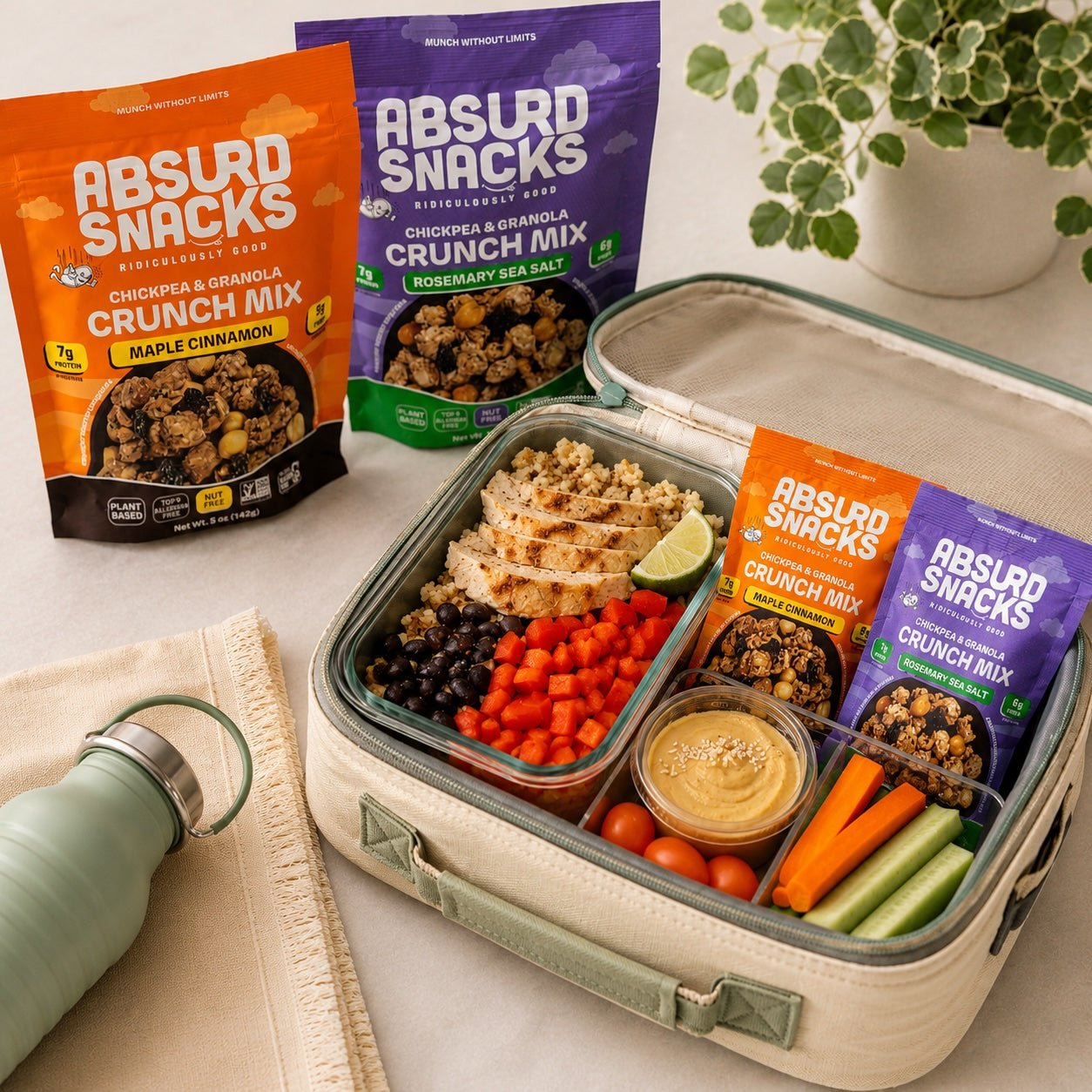 A healthy meal-prep lunch featuring grilled chicken, fresh vegetables, hummus, and Absurd Snacks Crunch Mixes, packed and ready to grab on a busy day.